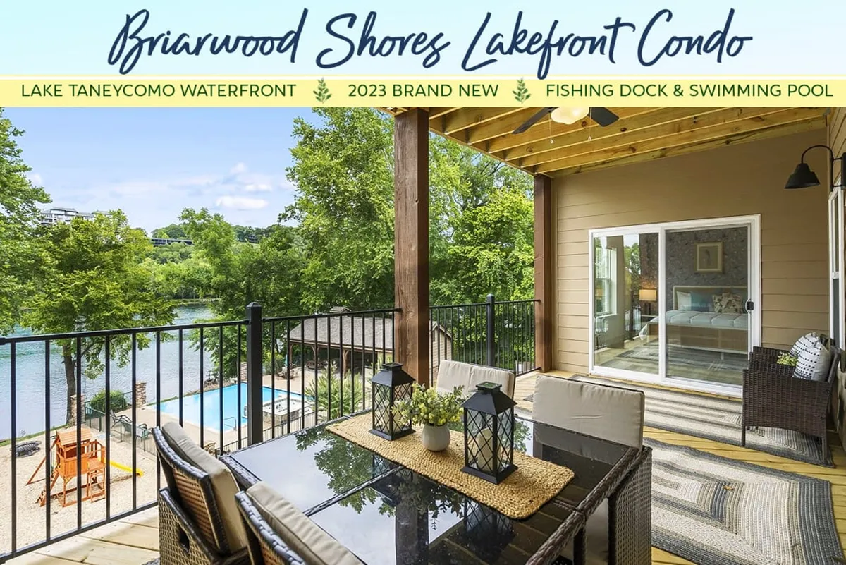An inviting outdoor dining table overlooks a scenic lake, with a clear view of the swimming pool and fishing dock in the background. The area encourages al fresco meals, swimming, and lakeside leisure, all steps from the community amenities.