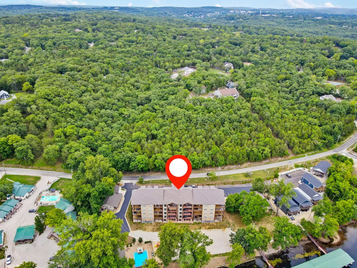 This image showcases the exterior view of an apartment complex with a swimming pool and greenery. The setting offers a glimpse into resort-style living, with spaces ideal for swimming, outdoor socializing, and enjoying the natural surroundings at different times of day.